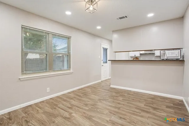 a view of a hallway with wooden floor and a window