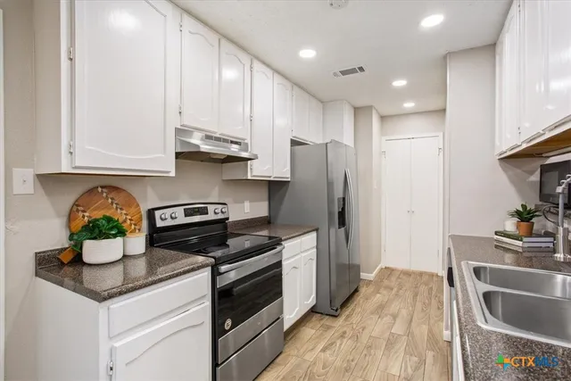 a kitchen with stainless steel appliances granite countertop a sink stove and refrigerator