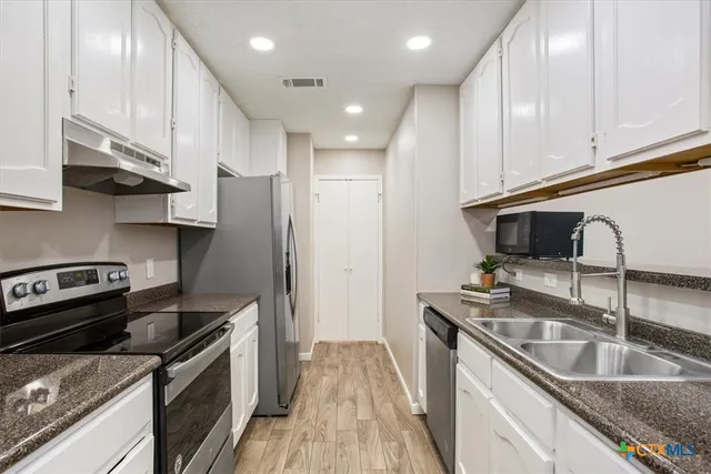 a kitchen with stainless steel appliances granite countertop a sink stove and refrigerator