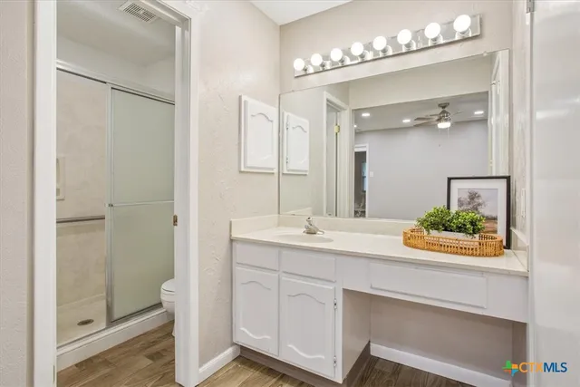 a spacious bathroom with a shower sink and mirror