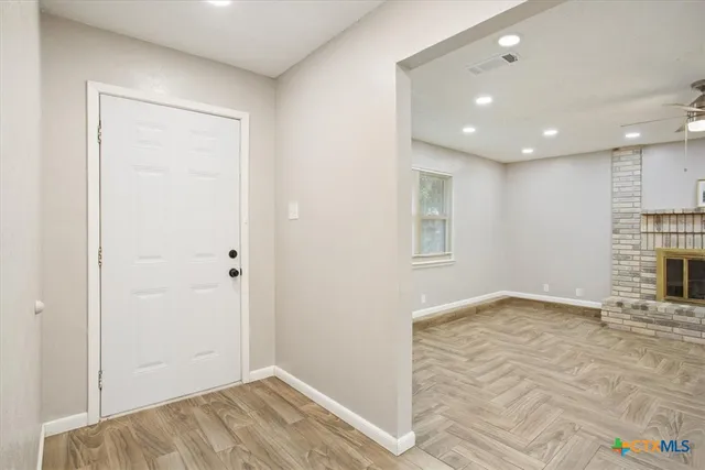 a view of empty room with wooden floor