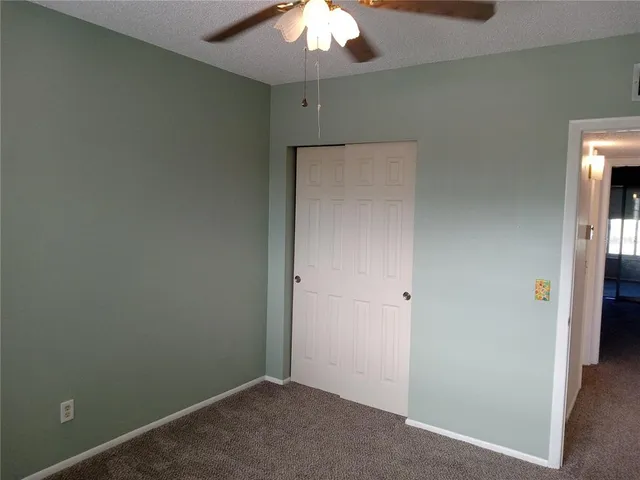 an empty room with a chandelier fan