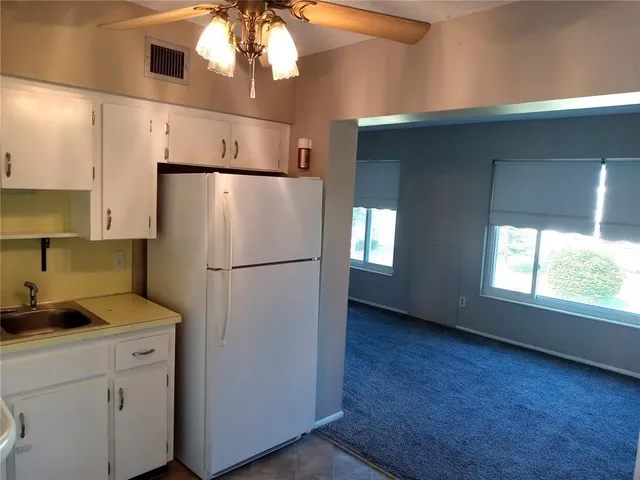 a kitchen with a refrigerator sink and cabinets