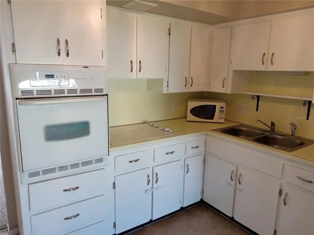 a kitchen with white cabinets and white appliances