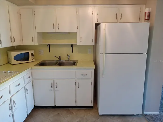 a white refrigerator freezer sitting inside of a kitchen