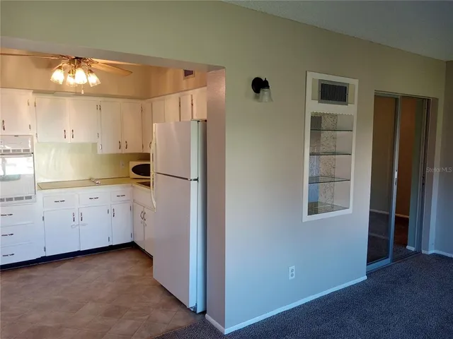 a kitchen with granite countertop cabinets and refrigerator