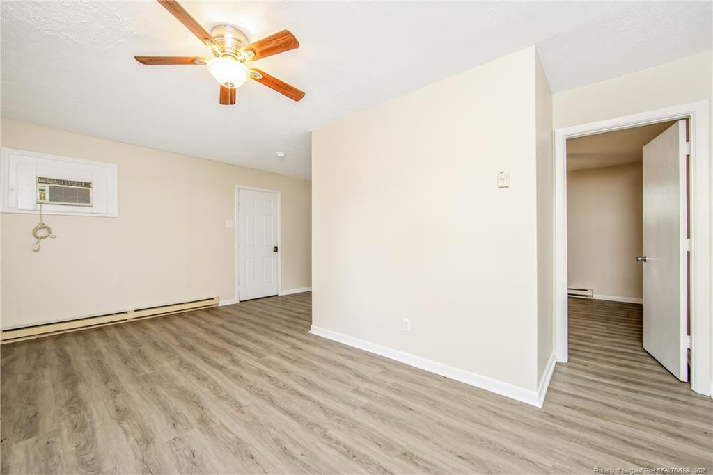 4305 Rosehill Road, Unit C Fayetteville, NC 28311 - Photo 6 of 7 an empty room with wooden floor and a ceiling fan