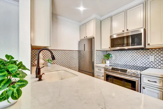 a kitchen with granite countertop a stove a sink and a microwave