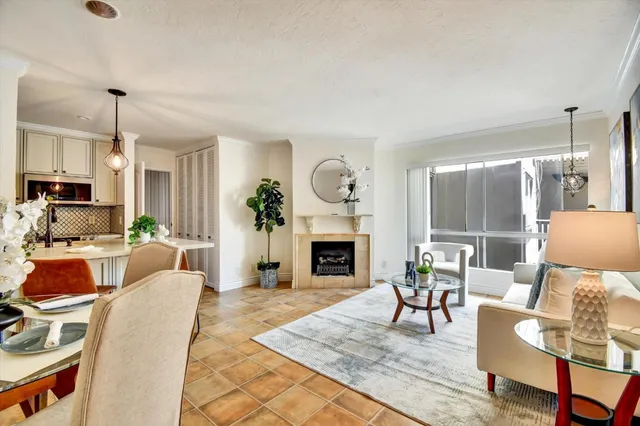 a living room with furniture a fireplace and a chandelier