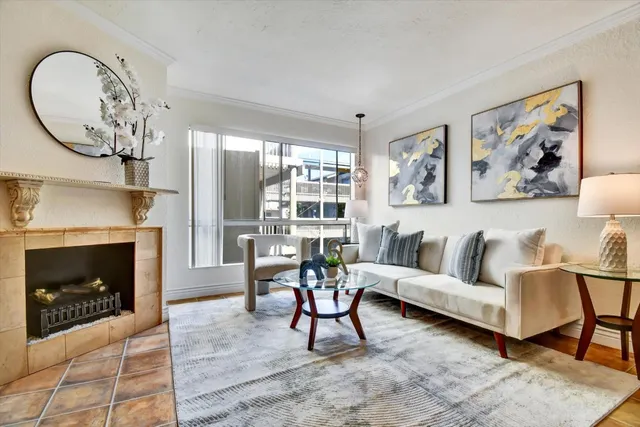 a living room with furniture a fireplace and a large window
