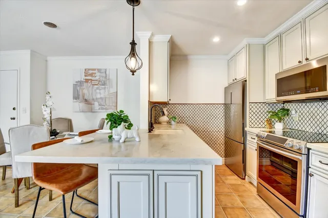 a kitchen with stainless steel appliances kitchen island granite countertop a table chairs in it and wooden floors