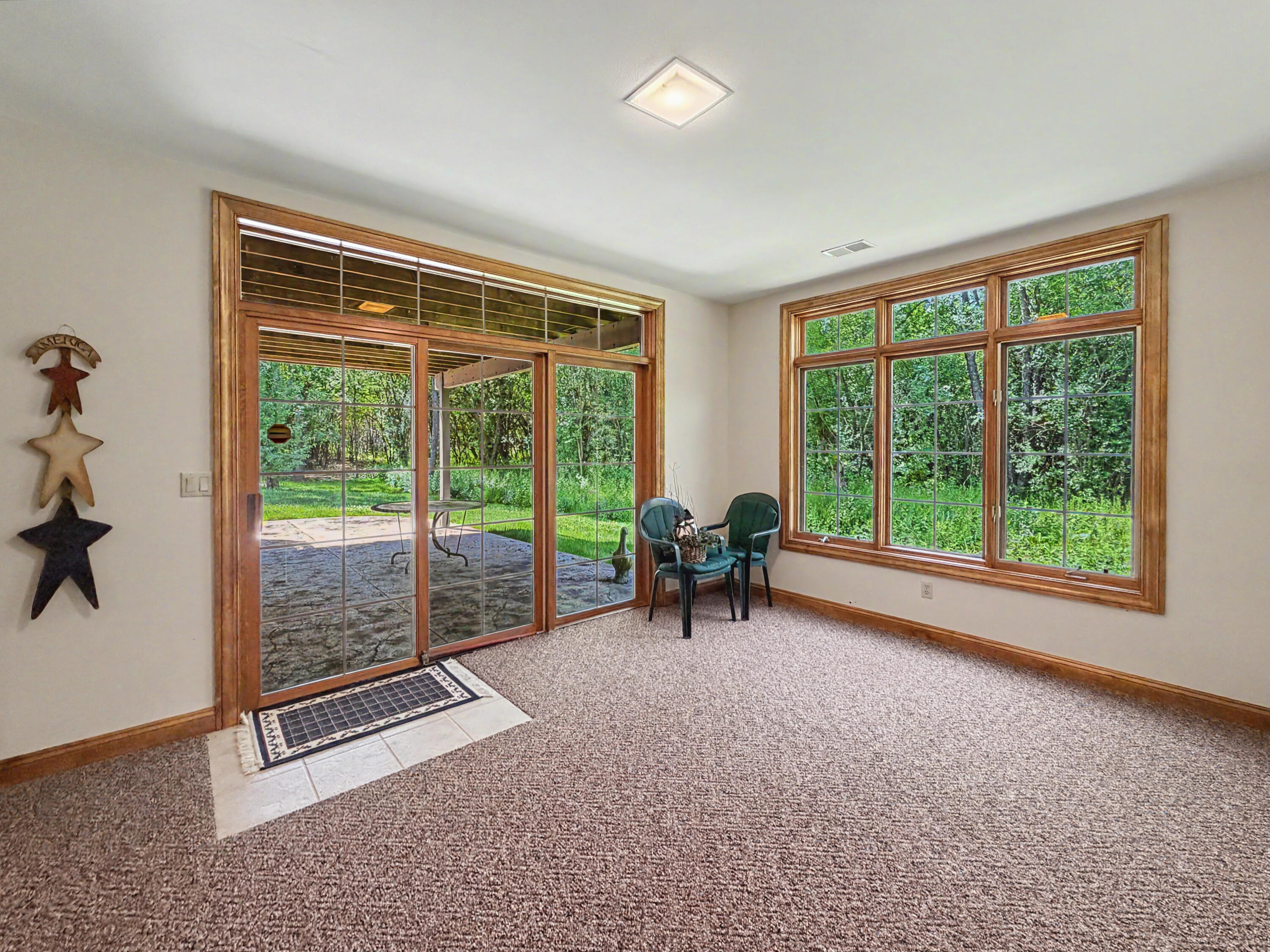 W291-s5245 Ridgefield Road Waukesha, WI 53189 - Photo 33 of 44 Sun-filled sitting room, and direct access to the covered stamped-concrete patio. Surrounded by mature trees and a private wooded backdrop