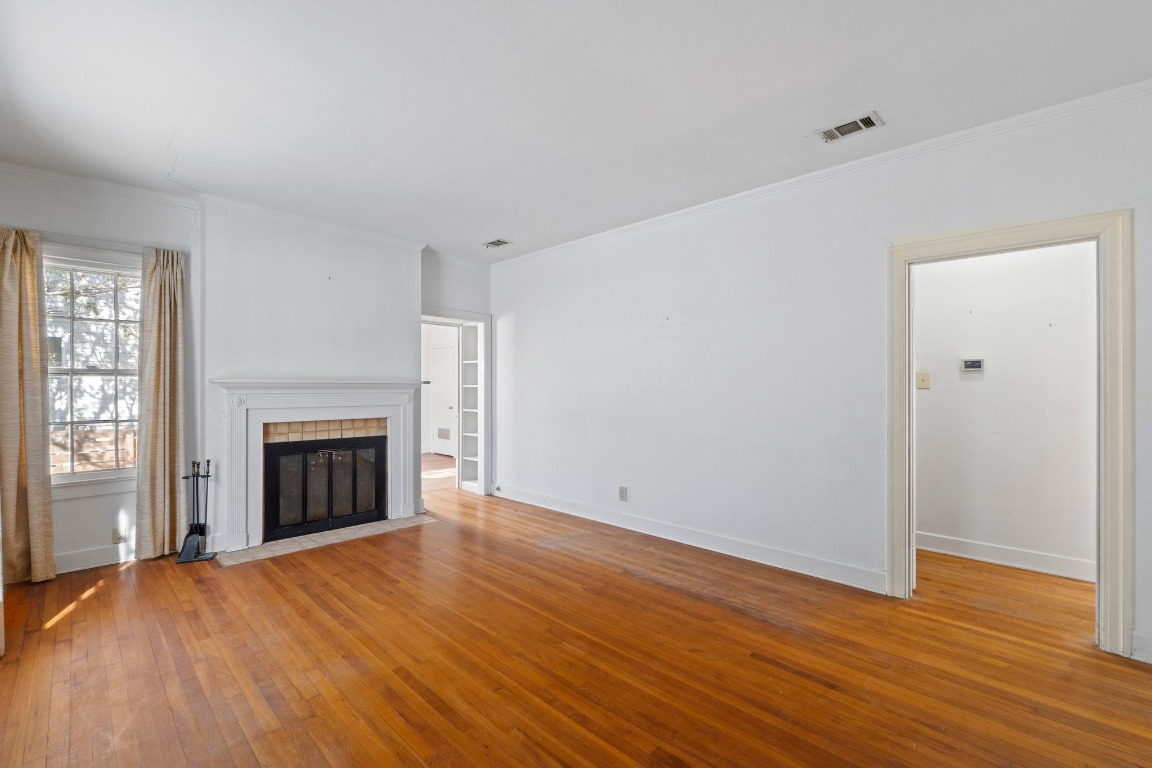 810 East 45th Street Austin, TX 78751 - Photo 9 of 25 an empty room with wooden floor fireplace and windows