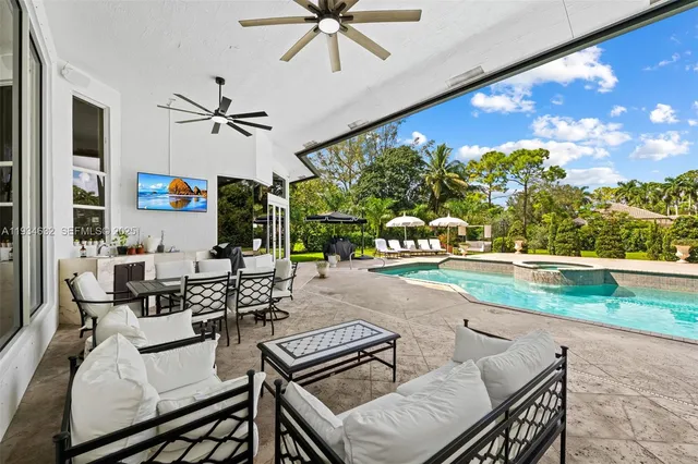 a swimming pool view with a seating space and a garden view