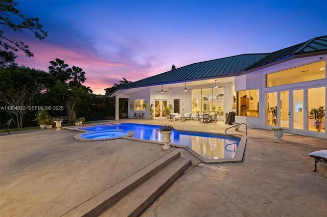 a view of swimming pool with a table and chairs in patio