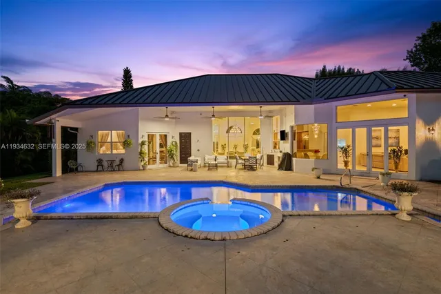 a view of swimming pool with a table and chairs under an umbrella