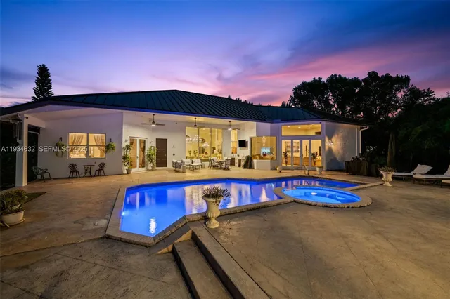 a view of a pool with a patio and a yard
