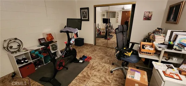 a view of an empty room with kitchen and a window