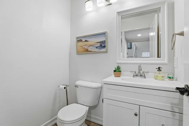 a bathroom with a toilet sink vanity and mirror