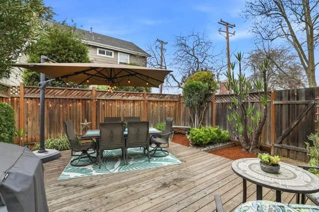 a view of a chairs and table in patio with wooden fence