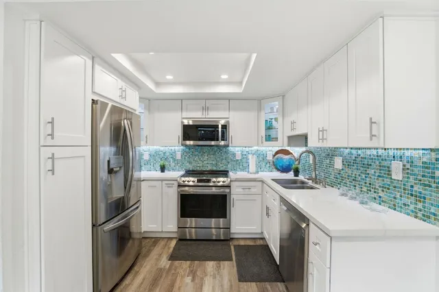 a kitchen with a sink a refrigerator a stove top oven and cabinets