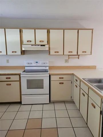 a kitchen with a stove sink and cabinets