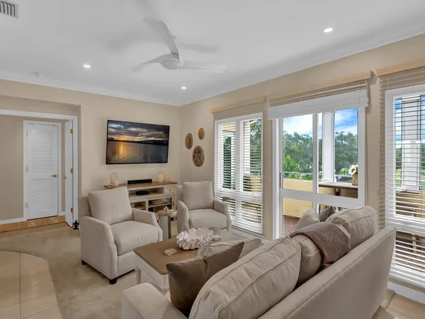 a living room with furniture a large window and a flat screen tv