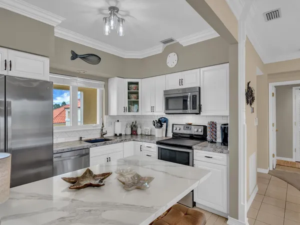 a kitchen with granite countertop a sink appliances and cabinets