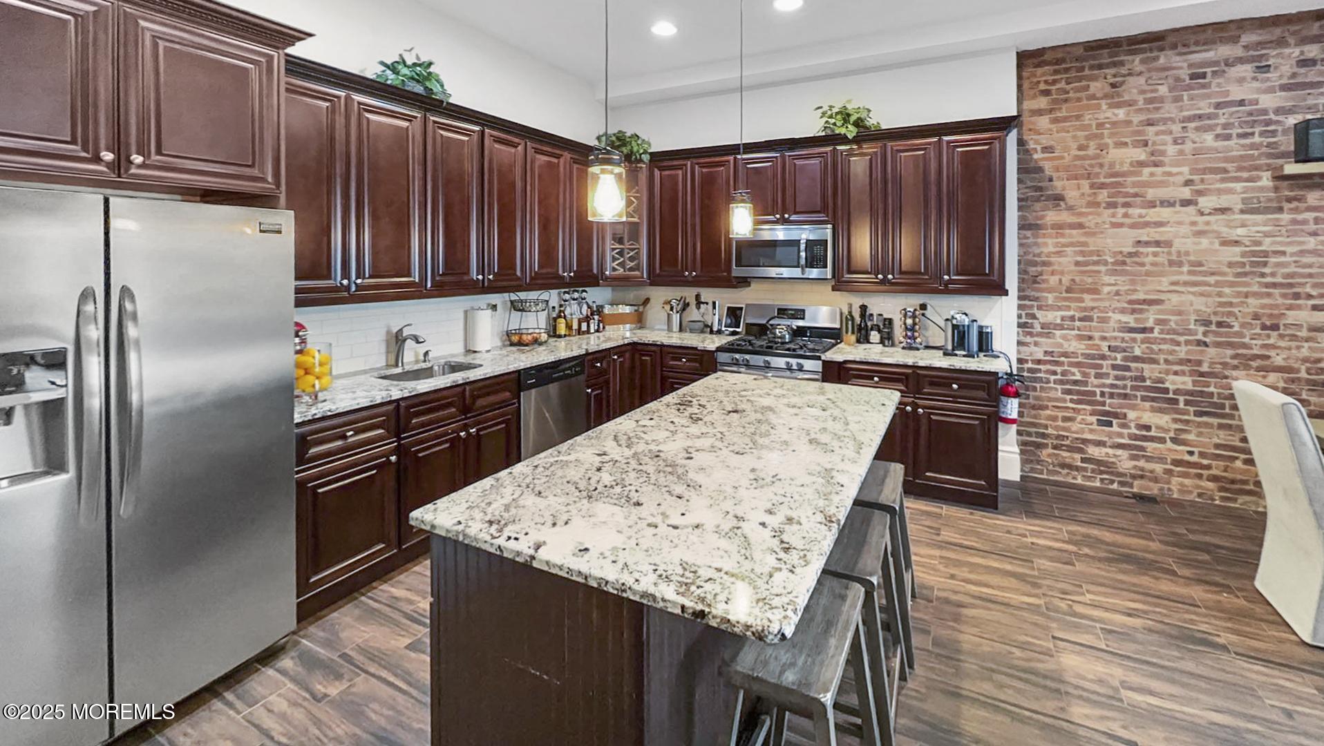 18 Broad Street, Unit 2F Red Bank, NJ 07701 - Photo 5 of 13 a kitchen with stainless steel appliances wooden cabinets a stove a sink and a refrigerator