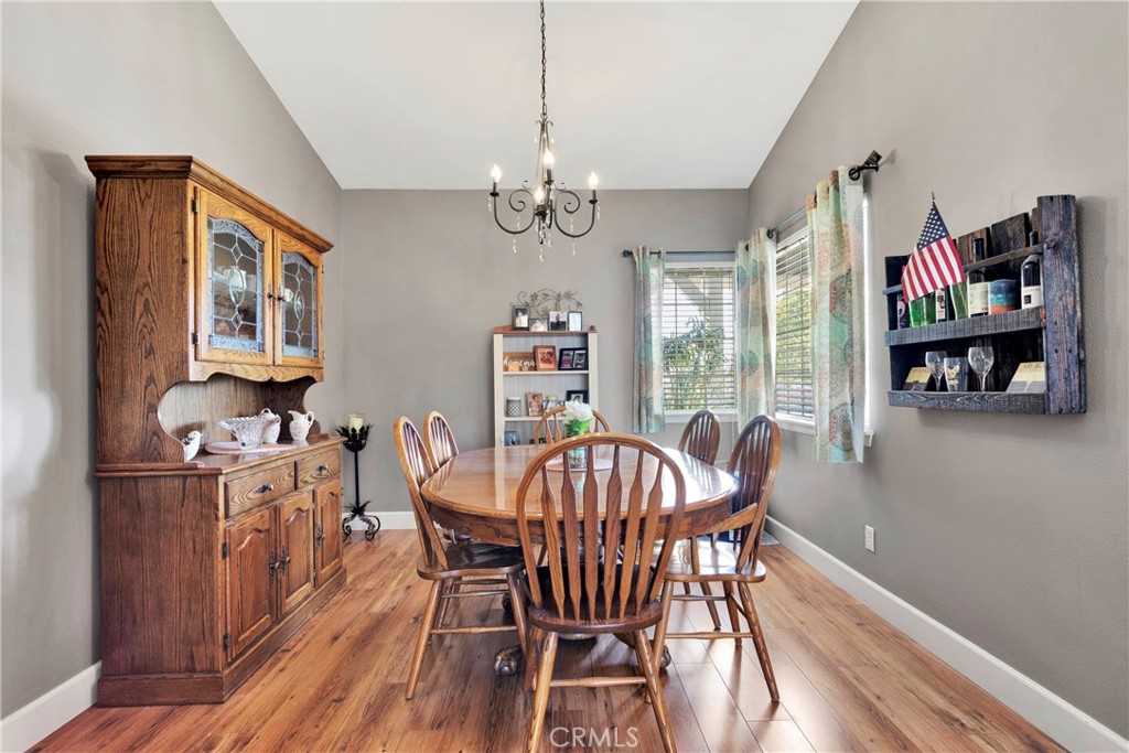 12949 Choco Road Apple Valley, CA 92308 - Photo 13 of 50 a view of a dining room with furniture a chandelier and wooden floor