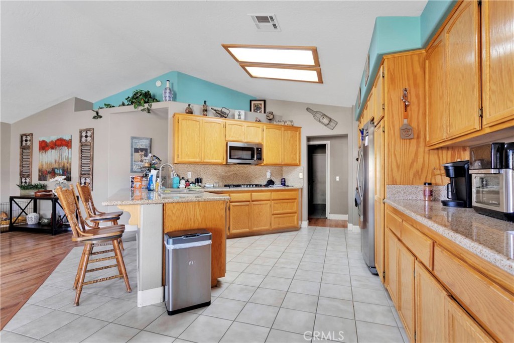12949 Choco Road Apple Valley, CA 92308 - Photo 14 of 50 a kitchen with stainless steel appliances granite countertop a sink and cabinets