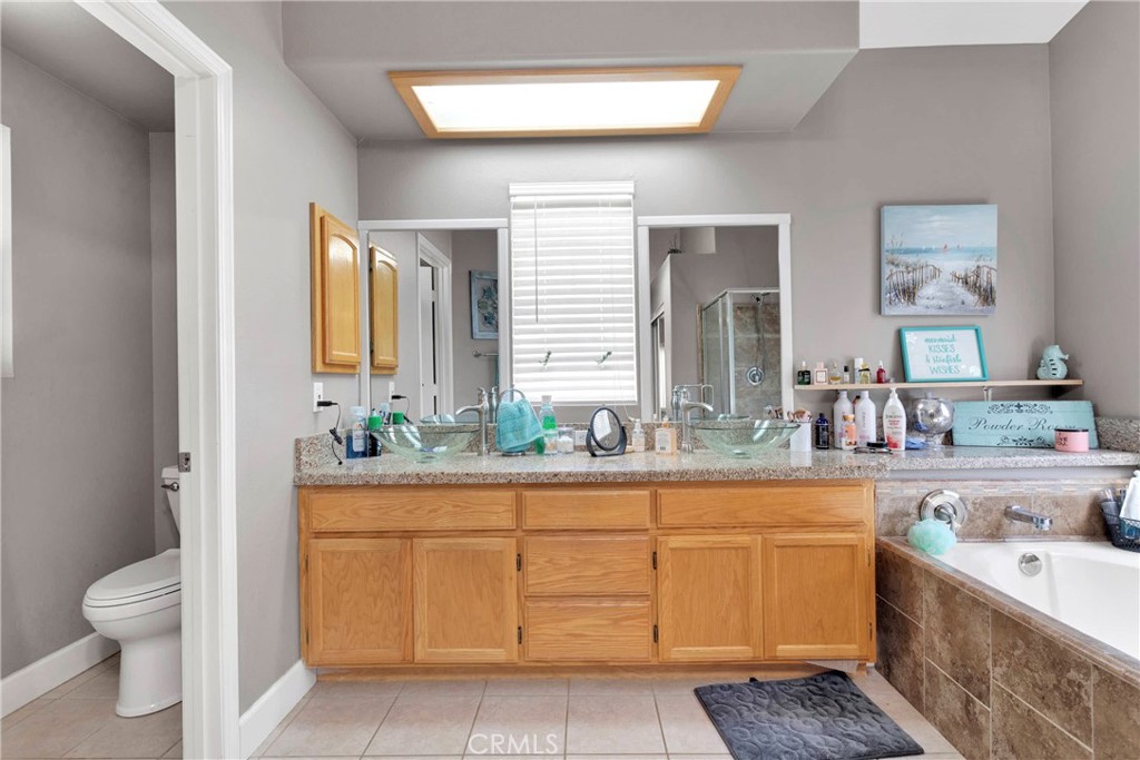 12949 Choco Road Apple Valley, CA 92308 - Photo 26 of 50 a bathroom with a granite countertop toilet sink and mirror