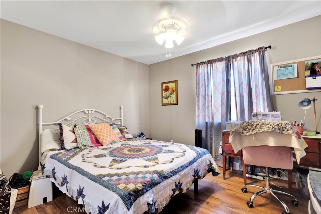 12949 Choco Road Apple Valley, CA 92308 - Photo 30 of 50 a bedroom with a bed and a chandelier