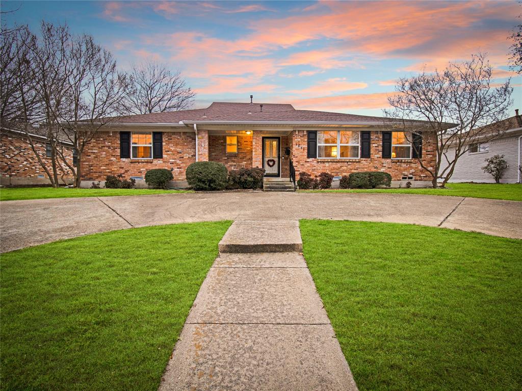 a front view of a house with a yard and trees