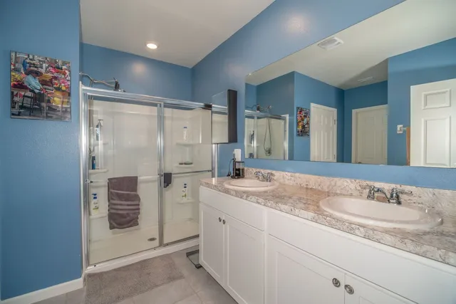 a bathroom with a granite countertop sink mirror and a shower