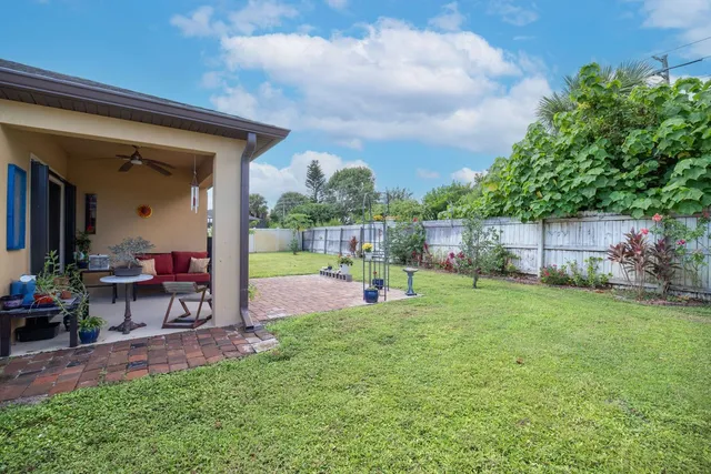 a view of a chair and table in backyard of the house
