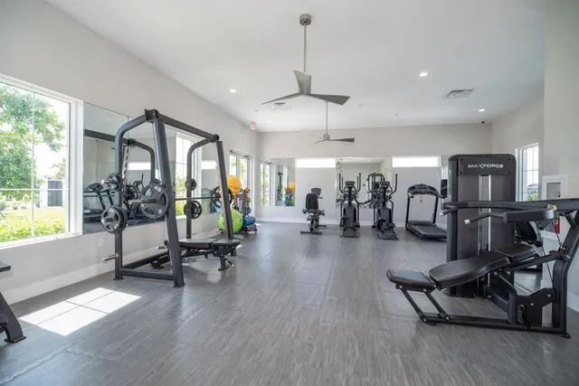 a living room with furniture gym equipment and a large window
