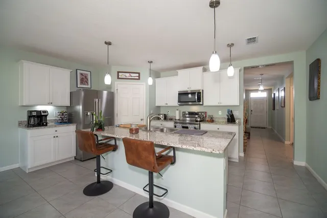 a kitchen with stainless steel appliances granite countertop a sink a stove and refrigerator