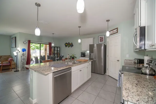 a kitchen with stainless steel appliances granite countertop a sink refrigerator and cabinets