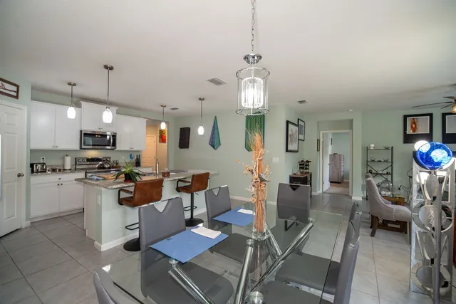 a view of a dining room and livingroom with furniture wooden floor a chandelier