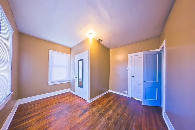 a very nice looking room with wooden floor and a bathroom