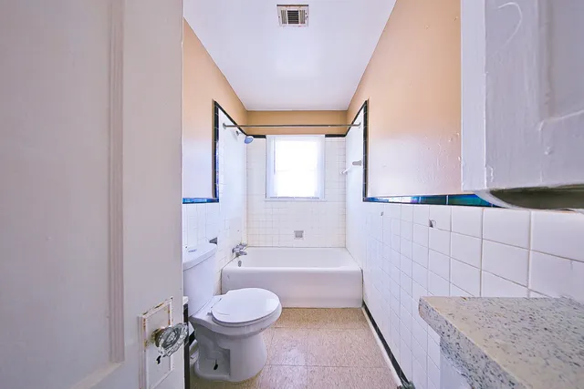 a bathroom with a granite countertop toilet a sink and a mirror