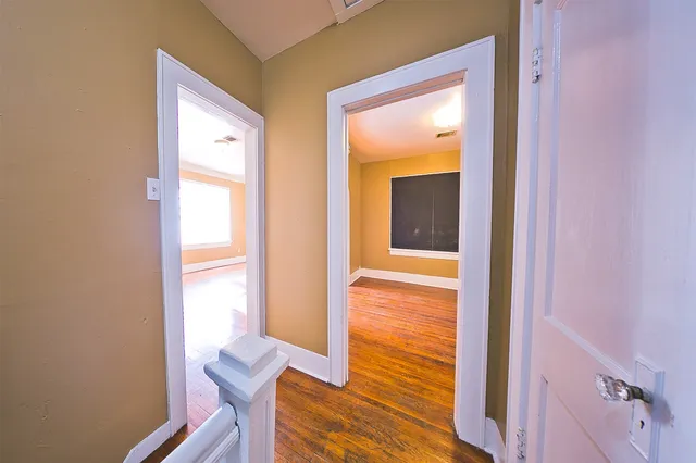 a view of a hallway with wooden floor and glass door