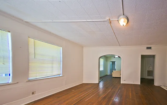 a view of empty room with window and wooden floor