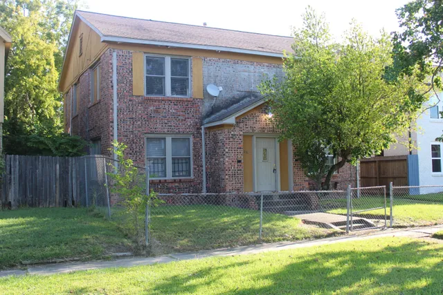 a view of a house with backyard and a tree