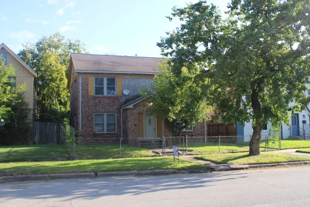 a view of a house with a backyard and a tree