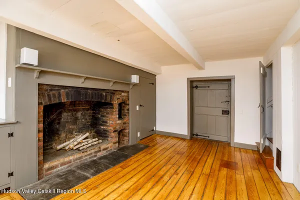 a view of a livingroom with wooden floor and kitchen space