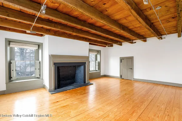 a view of empty room with wooden floor and fireplace
