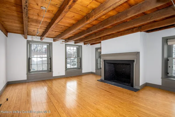 a view of empty room with wooden floor and fireplace