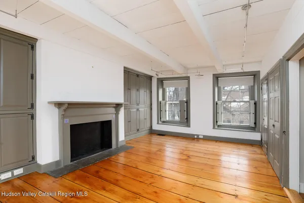 a view of an empty room with glass door and wooden floor